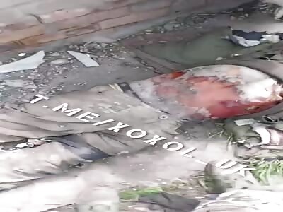 A Wagner mercenary shows off a corpse in Ukraine