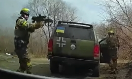 Somewhere in Ukraine, armed soldiers stopped a woman with a child 