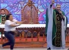Woman Sprints at Priest and Pushes Him Off Stage