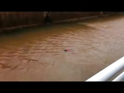Woman in Red Shirt Floating down a Canal is Intercepted by Police and Pulled over to the Side